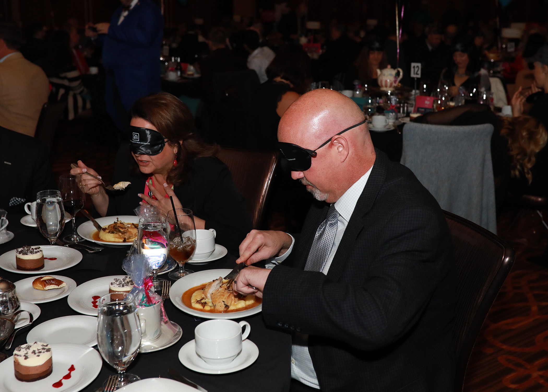 Gentleman at table eating with blindfold
