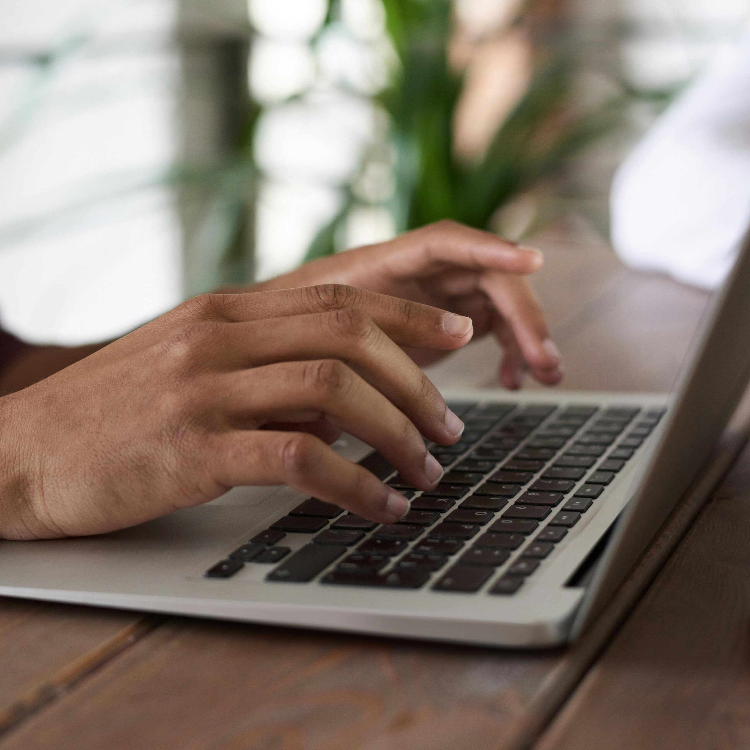 Person's hands typing on laptop