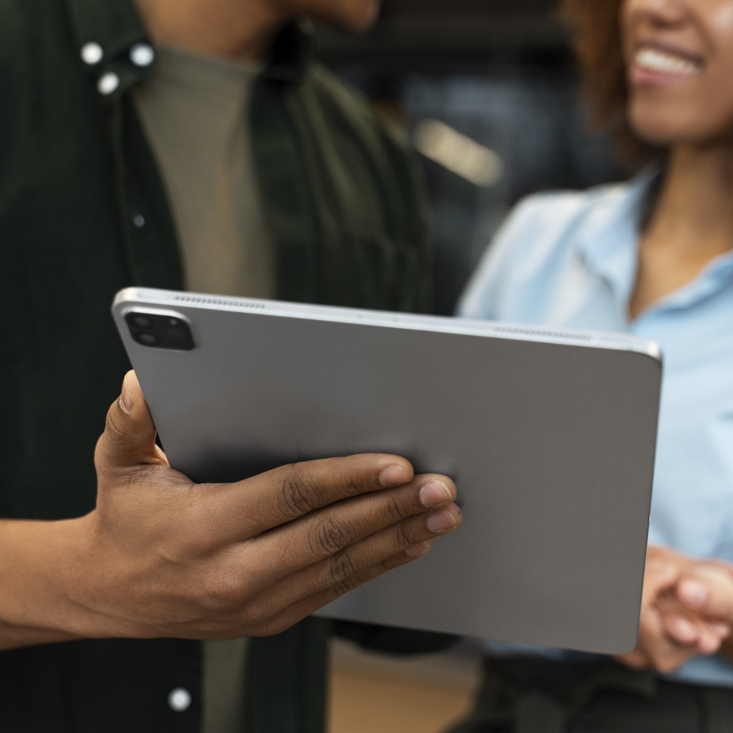 Close up image of two people's hands and an iPad